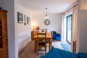 a dining room with a table and chairs and a clock at Splendid House Great Location to WAVE Surf & South West Water Park - Super Garden By StayStaycations in Bristol