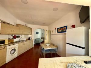 a kitchen with a white refrigerator and a table at Akonxego&Cia in Mourão