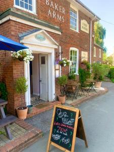 un panneau à la craie devant un bâtiment en briques dans l'établissement Daisy Cottage, à Child Okeford 2 autres photos