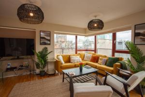 a living room with a yellow couch and a table at Beautiful Penthouse in City Centre Location in Glasgow