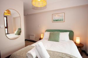 a bedroom with a bed and a mirror at Beautiful Penthouse in City Centre Location in Glasgow