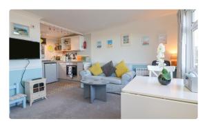 Una sala de estar con un sofá y una cocina. en 49 Sea Valley, en Bideford