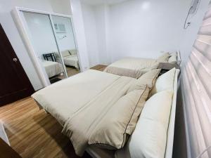 ein Schlafzimmer mit zwei Betten und einem Spiegel in der Unterkunft Homestay CDO - Ventura in Cagayan de Oro