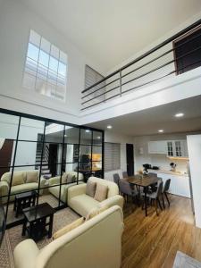 ein Wohnzimmer mit Sofas und einem Tisch sowie eine Küche in der Unterkunft Homestay CDO - Ventura in Cagayan de Oro