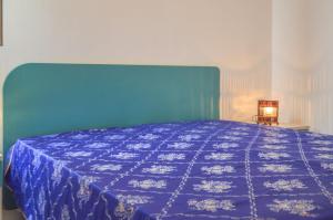 a bedroom with a blue bed with a blue blanket at Villetta Pinetata 452 in Ugento