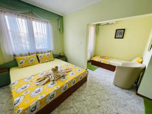 a bedroom with two beds and a chair in it at Kastela Guest House in Chernomorets