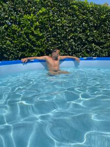 a man in a swimming pool with his arms out at B&B Villa Gaudium in Pompei