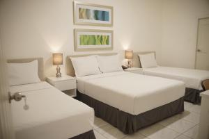 ein Hotelzimmer mit zwei Betten und zwei Lampen in der Unterkunft Manakin Hostal & Resto in Manta