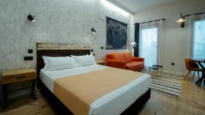 a hotel room with a bed and a chair at Aparthotel Luz de Gades - Suites Spa Gym - Adults Only in Cádiz