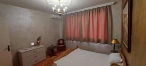 a bedroom with a white bed and a red curtain at Downtown Veliko Tarnovo 2 in Veliko Tŭrnovo