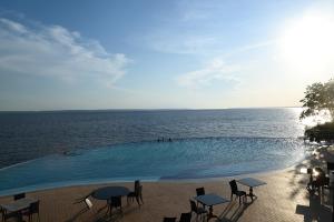 a swimming pool with tables and chairs next to the water at Tropical Executive Flat Suite 817 with View in Manaus