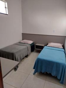 a room with two beds sitting next to each other at Quarto Solteiros Amigos - Queen's Hotel in Formosa