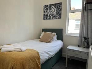 een kleine slaapkamer met een bed en een raam bij Lister House in Hartlepool
