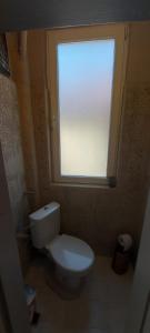 a bathroom with a white toilet and a window at Downtown Veliko Tarnovo 2 in Veliko Tŭrnovo +3 photos