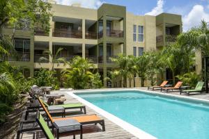 a resort swimming pool with chairs and a building at LOL-HA Hotel Boutique in Cancún