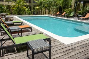 a swimming pool with chairs and a table and chairs at LOL-HA Hotel Boutique in Cancún