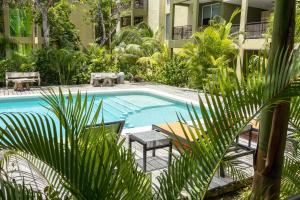 a swimming pool with a table and chairs next to a building at LOL-HA Hotel Boutique in Cancún