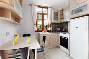 a kitchen with a table and a white refrigerator at Giorgi's Blue Apartments in Kalathas