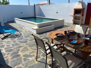 a patio with a table and chairs and a swimming pool at Casa da Oriola in Oriola