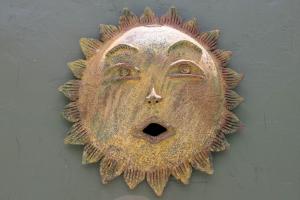 a metal mask with a face on a wall at LOL-HA Hotel Boutique in Cancún
