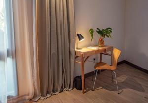 a desk with a lamp and a chair next to a window at Hotel Saint George in Puerto Iguazú