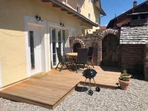 a wooden deck with a table and chairs on a house at Ferienwohnung Welschenkramer in Übersee