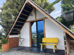 a small house with a yellow bench in front of it at Encanto Verde in Rionegro