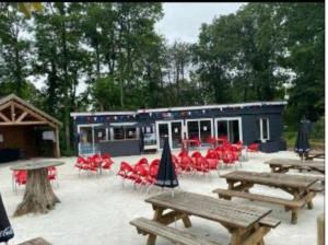a group of picnic tables and chairs in front of a building at Mobil home in Saint-Chéron