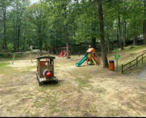 a playground with a small train in a park at Mobil home in Saint-Chéron