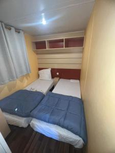 a small room with two beds and a window at Mobil home in Saint-Chéron