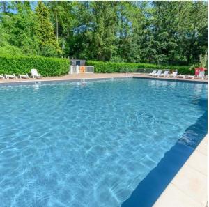 a large swimming pool with blue water at Mobil home in Saint-Chéron