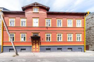 a large wooden building with a red door at Peaceful studio with desk & free parking near city center in Tallinn