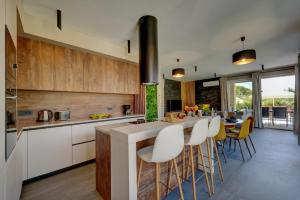 a kitchen with white cabinets and a table with chairs at Villa Pieron&Bavigo with Pool, Jacuzzi and Sauna in Marčana