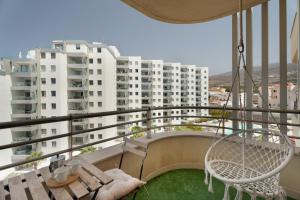 a balcony with a swing and a table and chairs at Apto Sol Paraiso Sunset View in Adeje