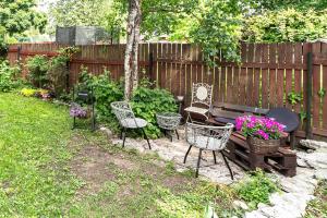 a garden with a bench and chairs and a fence at Peaceful studio with desk & free parking near city center in Tallinn
