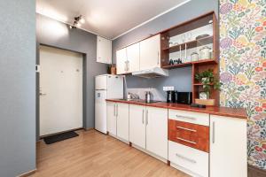 a kitchen with white cabinets and a refrigerator at Peaceful studio with desk & free parking near city center in Tallinn +19 photos