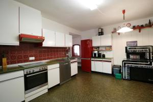 a kitchen with white cabinets and a red refrigerator at Gästehaus Sonnenheim, Friedenweiler, Titisee in Friedenweiler