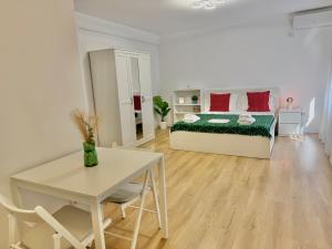 une chambre blanche avec un lit et une table dans l'établissement Sky Residence Airport Therme Otopeni 5, à Otopeni 14 autres photos