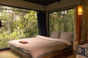 a bedroom with a bed and a large window at Sum Villa Homestay Mang Den in Kon Von Kla