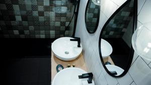a bathroom with two sinks and two mirrors at Aparthotel Luz de Gades - Suites Spa Gym - Adults Only in Cádiz