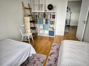 a bedroom with a bed and a book shelf with books at Quiet City Style Apartment in Täby