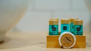 a group of four green and yellow bottles of toothpaste at Aparthotel Luz de Gades - Suites Spa Gym - Adults Only in Cádiz