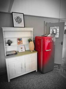 a red refrigerator in a room with a table at The Fox Den in Reading +15 photos