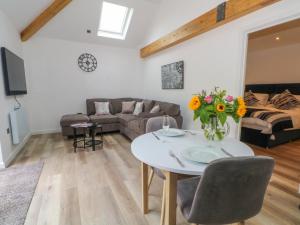 a living room with a couch and a table with flowers on it at Studio in Chester