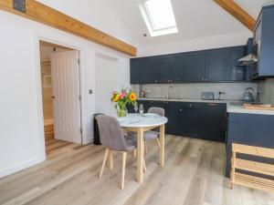 a kitchen with a table with chairs and a vase of flowers at Studio in Chester