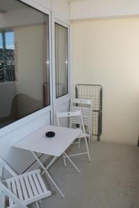 d'une table blanche et de deux chaises sur un balcon. dans l'établissement Ferienappartement K111 für 2-4 Personen in Strandnähe, à Schönberg in Holstein 5 autres photos