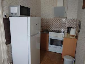 a kitchen with a white refrigerator and a microwave at Dzīvoklis Vecliepājā in Liepāja +2 photos