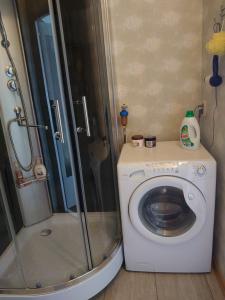 a bathroom with a shower and a washing machine at Dzīvoklis Vecliepājā in Liepāja