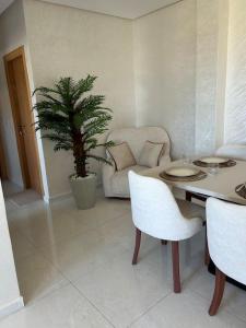 a living room with a table and a palm tree at Nour Beach Cabo in Martil