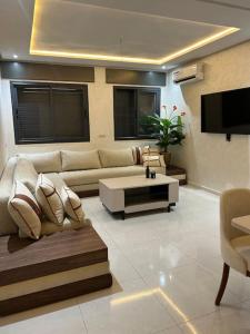 a living room with a couch and a coffee table at Nour Beach Cabo in Martil